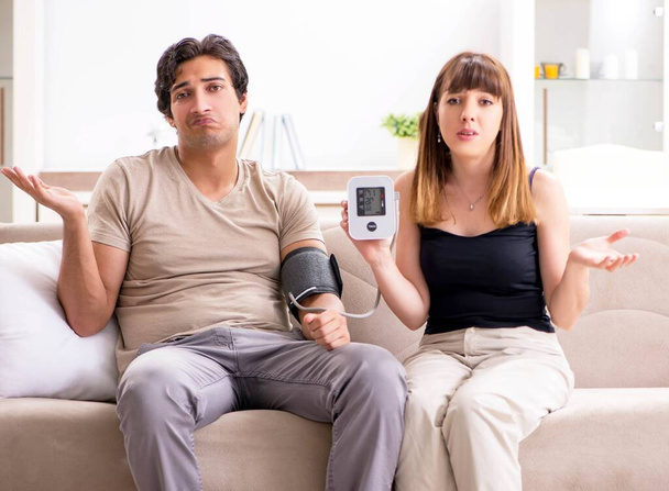 Wife checking husbands blood pressure - Photo, Image