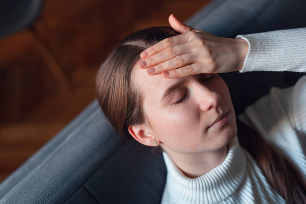 Sick girl at home with headache feeling faint vertigo holding head in pain with fever and migraine. - Fotografie, Obrázek