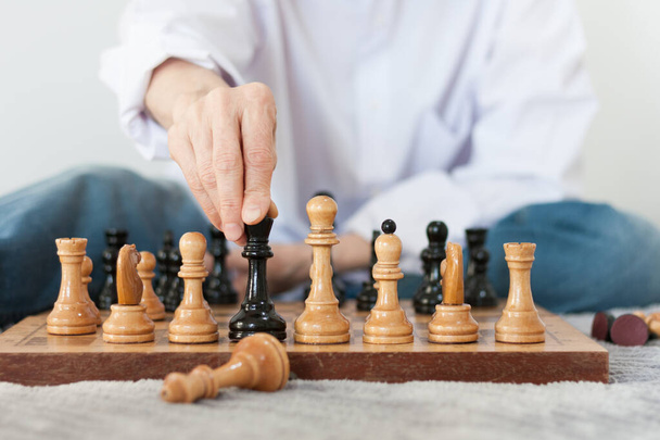 Strategy concept, hand of woman moving wooden chess figure in play, management or leadership competition business success background - Fotografie, Obrázek