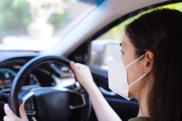 Женщина носит знак или респиратор во время вождения автомобиля
 - Фото, изображение