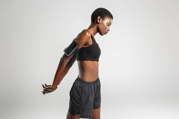 Image of african american sportswoman doing exercise while working out isolated over white background - Valokuva, kuva