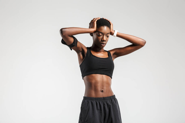 Image of african american sportswoman grabbing her head while working out isolated over white background - Foto, Imagem