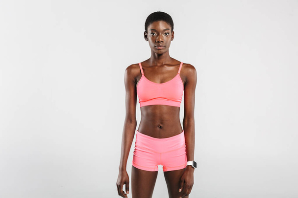 Image of athletic african american woman in sportswear posing and looking at camera isolated over white background - Fotó, kép