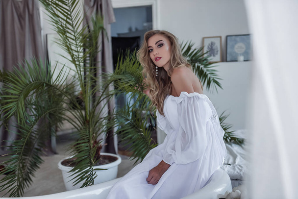 Delicate, airy and modern image of the bride. A beautiful girl in a light and beautiful white dress holds an unusual flower in her hands. Unusual bouquet of a modern bride. Selective Focus - Foto, Bild