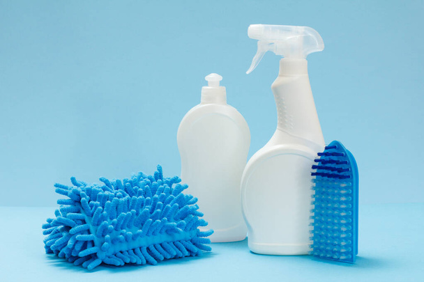 Bouteilles en plastique de liquide vaisselle, nettoyant pour vitres et carreaux, chiffon et brosse sur fond bleu. Set de lavage et de nettoyage
. - Photo, image