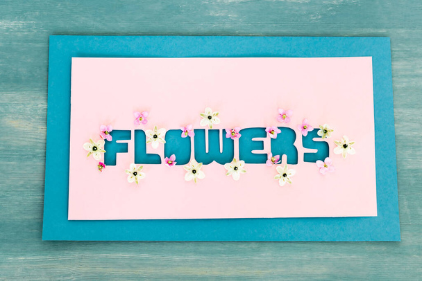 top view of greeting card with flowers lettering on blue textured surface,  - Fotoğraf, Görsel