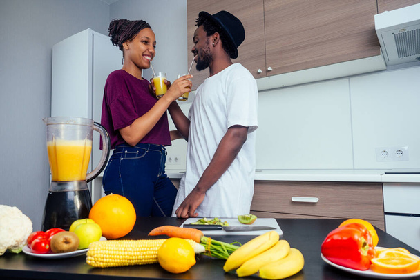 latino woman and man working at juice bar and cutting fruits, making fresh smoothies from bananas,orange and melon. she useing eco metal reusable tubes and glass - Foto, Imagem