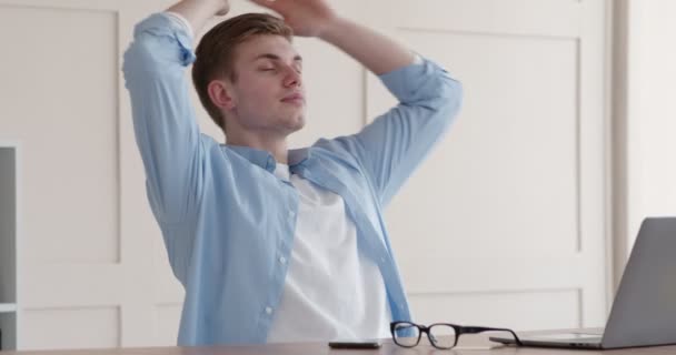 Ευτυχισμένος τύπος που βγάζει γυαλιά και χαλαρώνει στο χώρο εργασίας - Πλάνα, βίντεο