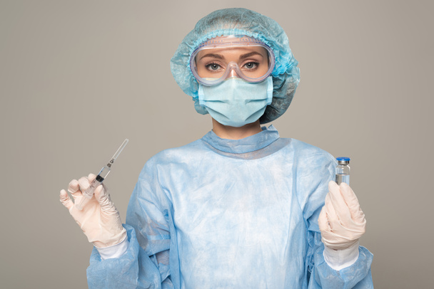 Güvenlik Google 'ındaki doktor ve tıbbi maske aşı ve şırınga kavanozunu gri renkte tutuyor. - Fotoğraf, Görsel