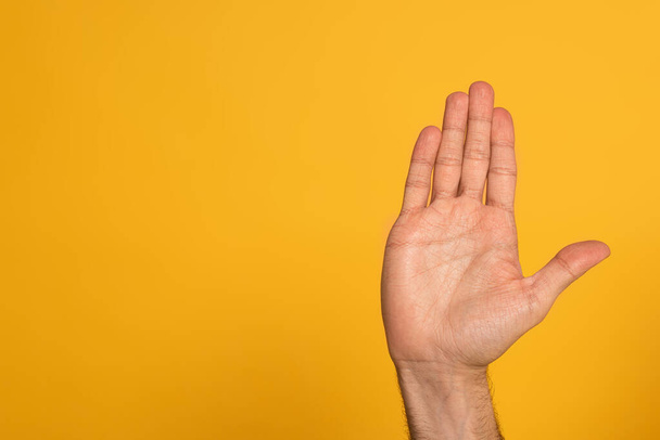 Vista recortada de la mano masculina que muestra la letra cirílica del lenguaje de signos aislado en amarillo
  - Foto, Imagen