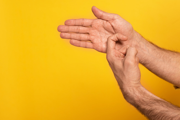 Cropped view of man showing gesture in deaf and dumb language isolated on yellow  - Fotoğraf, Görsel