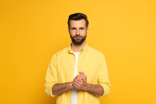 Handsome man showing marriage sign in deaf and dumb language on yellow background - Fotoğraf, Görsel