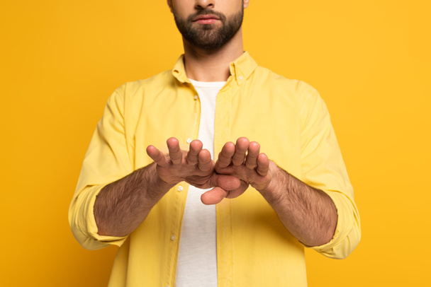 Vista cortada do homem mostrando gesto em língua surda e muda em fundo amarelo
  - Foto, Imagem