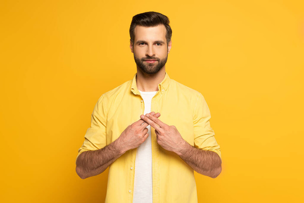Man using deaf and dumb language on yellow background - Foto, afbeelding