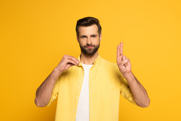 Hombre barbudo mostrando letras mientras usa lenguaje sordo y mudo sobre fondo amarillo
 - Foto, imagen