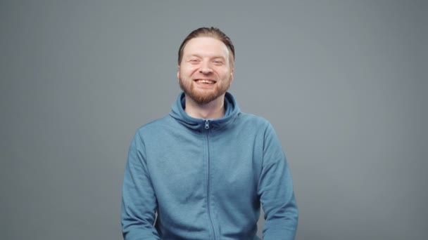 Video eines lachenden blonden Mannes im blauen Sweatshirt - Filmmaterial, Video