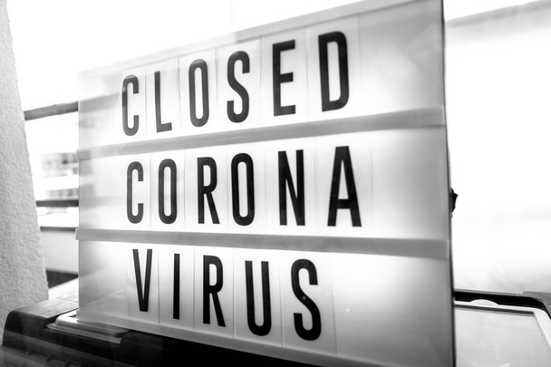 Закрытый бизнес для вспышки пандемии CoronaVirus, знак закрытия на фоне баннера розничного магазина. Правительственное закрытие ресторанов, магазинов, несущественных услуг
. - Фото, изображение