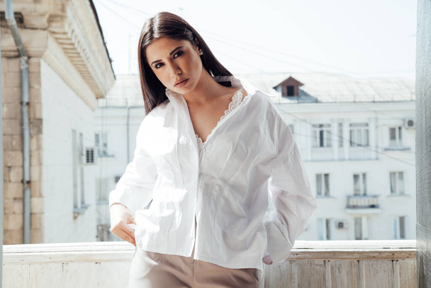 Портрет красивой восточной модной брюнетки в белой рубашке и шортах
 - Фото, изображение