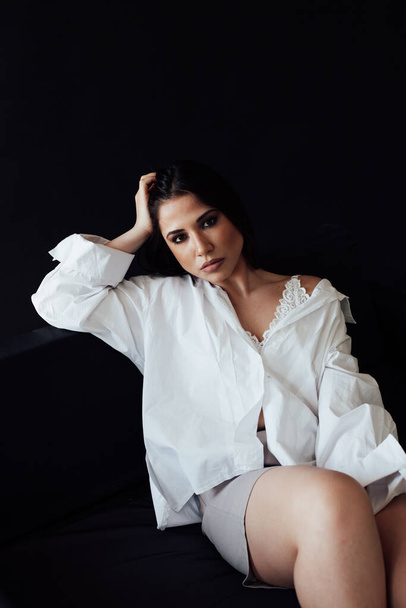 Portrait of a beautiful oriental fashionable brunette woman in a white shirt and shorts - Photo, Image
