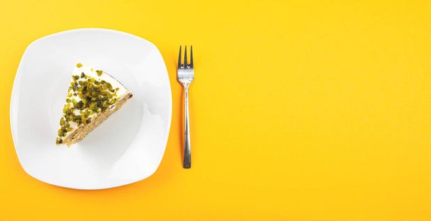 top view of piece of carrot pistachio cake on plate - Zdjęcie, obraz
