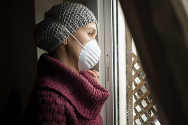 Γυναίκα με μάσκες προσώπου σε εσωτερικούς χώρους στο σπίτι, ιός Corona και καραντίνα έννοια - Φωτογραφία, εικόνα