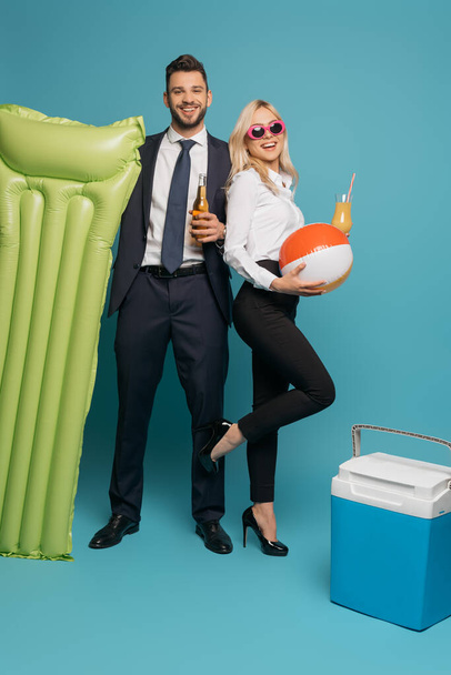 happy businesspeople with drinks, inflatable mattress and portable fridge on blue background - Fotografie, Obrázek
