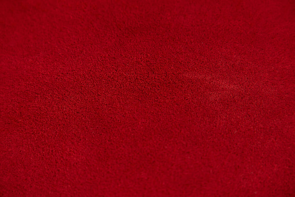 Rode matte achtergrond van suède stof, close-up. Fluwelen textuur van naadloos leer. Voelde materiële macro. Rode suède textuur. Stoffen, leer, materiaal voor ontwerpers. - Foto, afbeelding