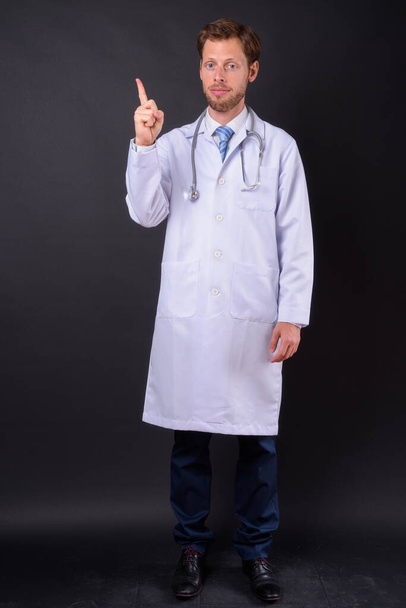 Студійний знімок красивого бородатого лікаря на чорному тлі
 - Фото, зображення