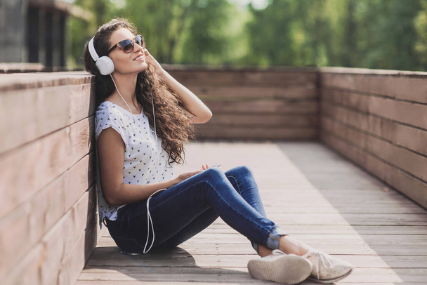 young girl with headphones outdoors - Фото, изображение