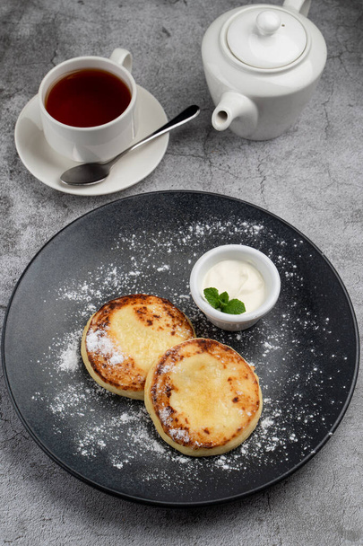 Traditional Russian cuisine: cottage cheese patties with sour cream - Fotoğraf, Görsel