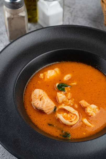 Горячий и острый томатный суп из морепродуктов с лососем, креветками и кальмарами, закрыть
  - Фото, изображение