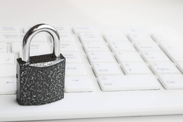 Beyaz bir klavyeye seçici odaklı asma kilit. Siber güvenlik kavramı. Güvenlik Kilidi - Fotoğraf, Görsel