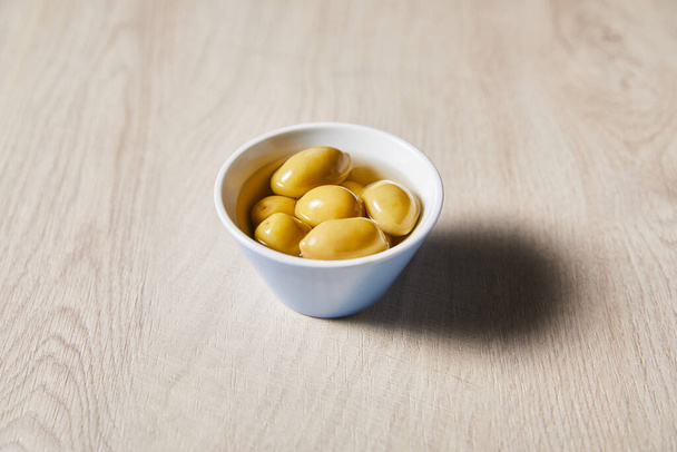 fresh olives in bowl on wooden table - Foto, Imagem