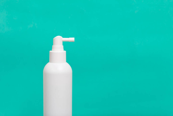 White plastic spray gun. With a disinfectant. On a green background. - Foto, afbeelding