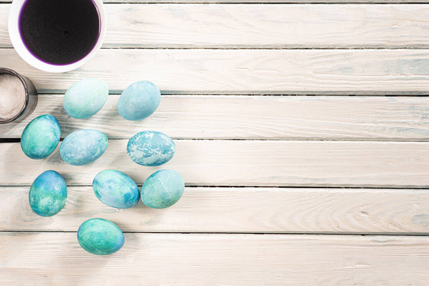 on a white background in a yellow plate are blue marble eggs lie as an Easter symbol - Fotoğraf, Görsel
