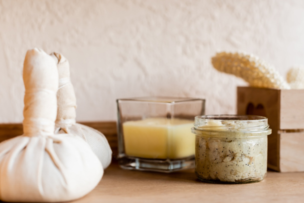 selective focus of herbal bags near clay mask in jar and candle  - Фото, зображення