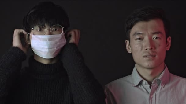 Δύο Κινέζοι ο ένας μετά τον άλλον φορώντας ιατρικές μάσκες κατά του covid-19 - Πλάνα, βίντεο