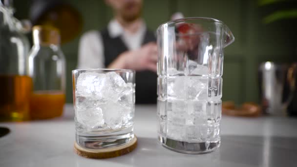 Mixing a cocktail from a variety of liquids in an ice glass. - Video
