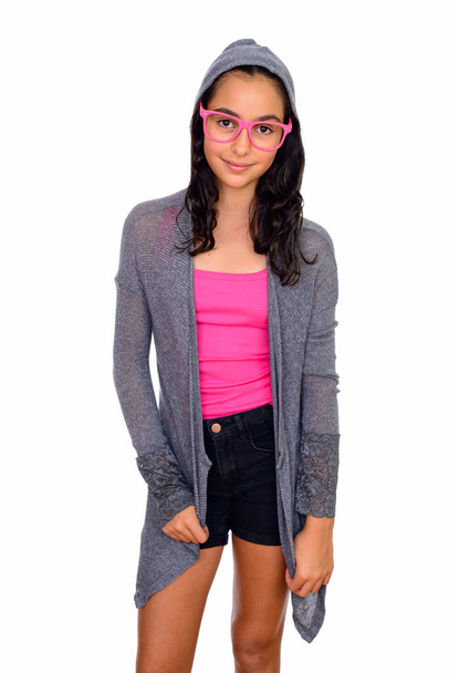 Studio shot of young beautiful teenage girl as nerd with eyeglasses isolated against white background - 写真・画像