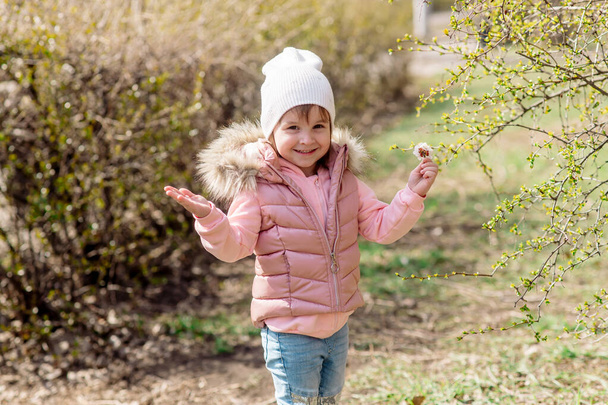 Little girl walks in nature in the spring park - Фото, зображення