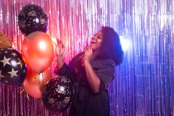 Gyönyörű fekete nő, aki élvezi a bulizást. Születésnapi party, klubok és ünnepek koncepciója. - Fotó, kép