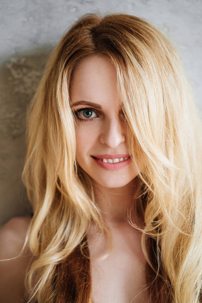 Portrait of young blonde woman. She is smiling - Фото, изображение