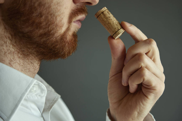 Imagen de cerca del sommelier que examina el olor del corcho de vino
 - Foto, imagen