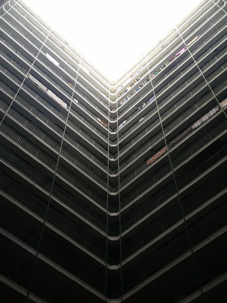 Vista de ángulo alto abstracta de un atrio de edificio distópico con líneas definidas y sombras oscuras, Hong Kong
 - Foto, imagen