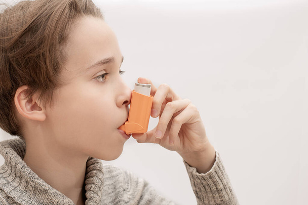 niño, adolescente aplica la inhalación broncodilatadora, inhalar el aerosol medicamento, asma bajo control
 - Foto, imagen