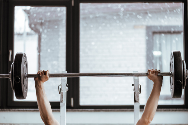 vista recortada de deportista fuerte haciendo ejercicio con barra en el gimnasio
  - Foto, Imagen
