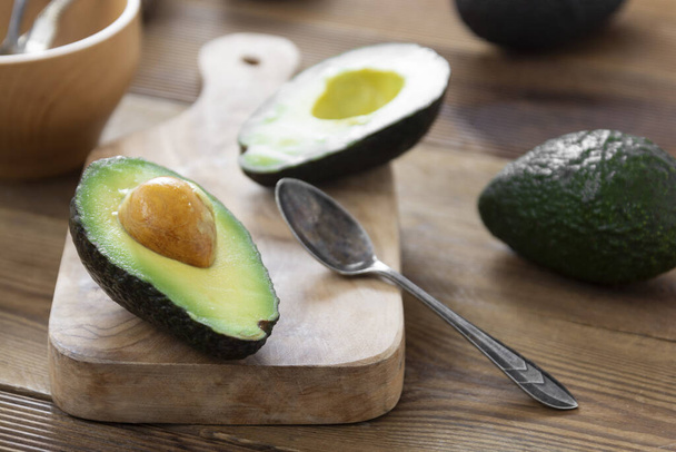 Avocado on wooden table, isolated. Healthy food. Guacamole ingredient. - 写真・画像