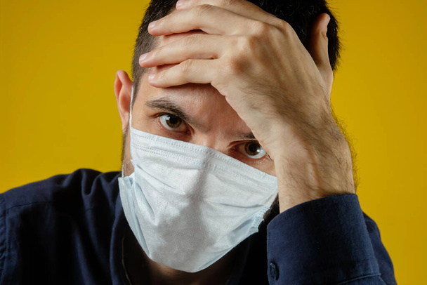 Tıbbi maskeli adam koronavirüs ve karantina yüzünden üzgün.. - Fotoğraf, Görsel
