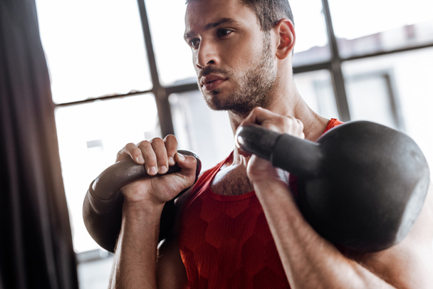 selective focus of athletic sportsman exercising with heavy dumbbells  - Φωτογραφία, εικόνα