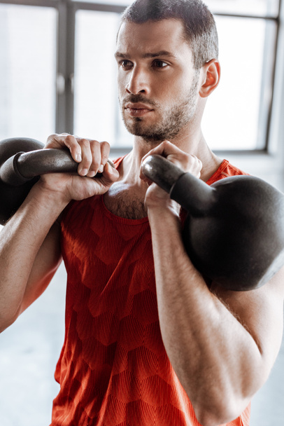 athletic and bearded man exercising with heavy dumbbells  - Foto, afbeelding